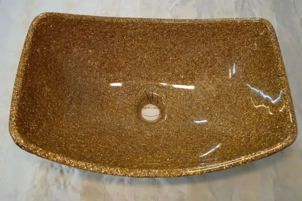 Golden Sail vessel sink with a curved boat-like silhouette, gold crystal interior, and dark textured artisan exterior by Majestics Group.