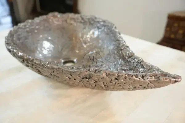 Elongated leaf-shaped artisan washbasin with textured silver leaf finish by Majestics Group.