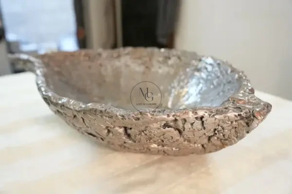 Elongated leaf-shaped artisan washbasin with textured silver leaf finish by Majestics Group.